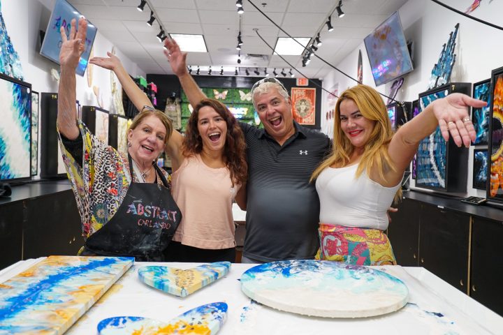 a group of people standing in front of a birthday cake