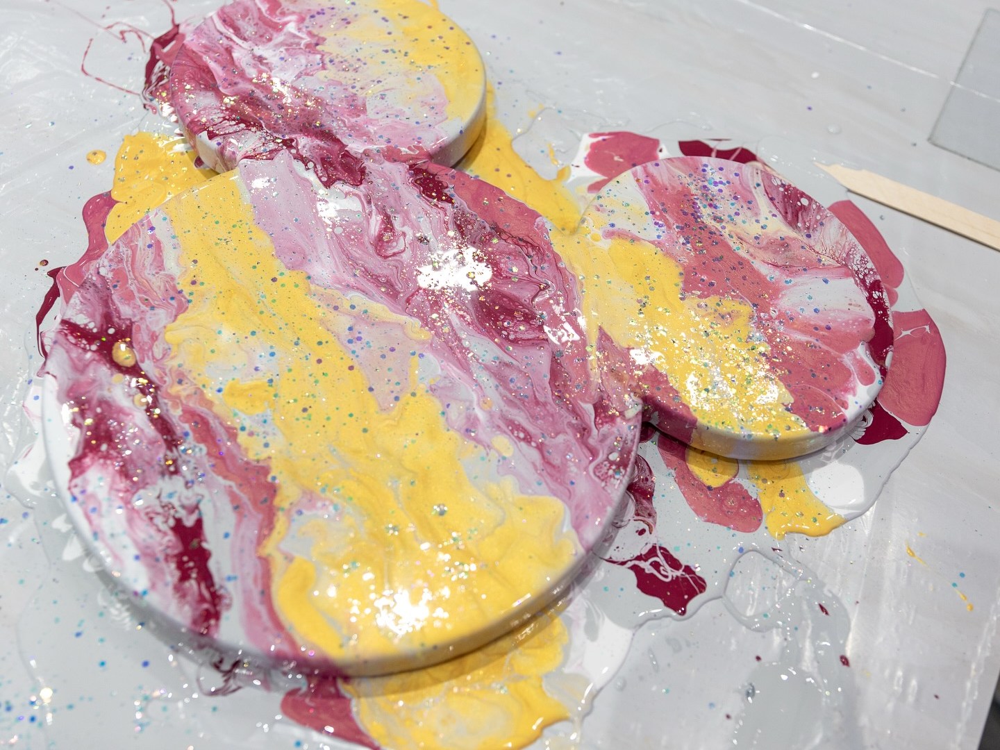 Three circles with mixed pink and yellow paint on a white surface.