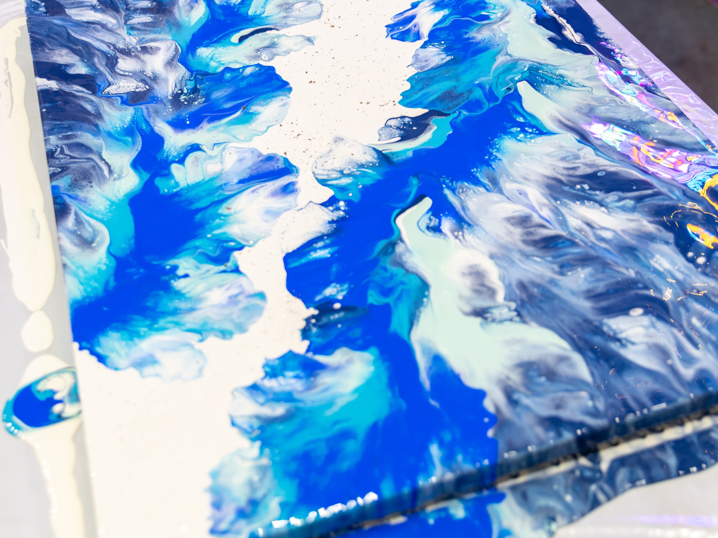 Abstract blue and white fluid art painting on a table.