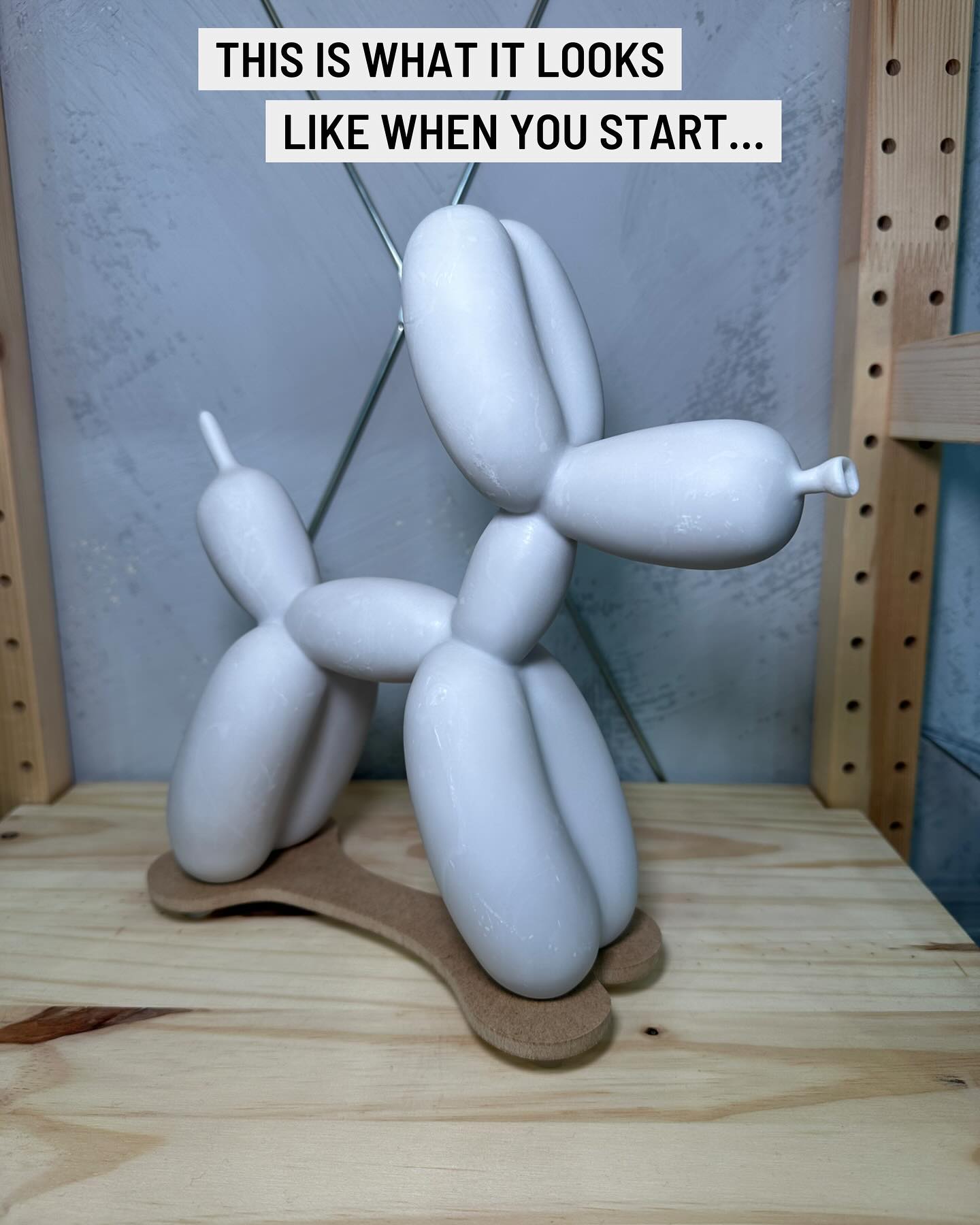 White balloon dog sculpture on a wooden surface with a text overlay.