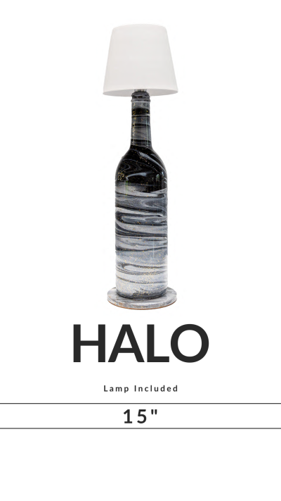 A table lamp with a black bottle base and white shade, labeled 'HALO' 15 inches tall.