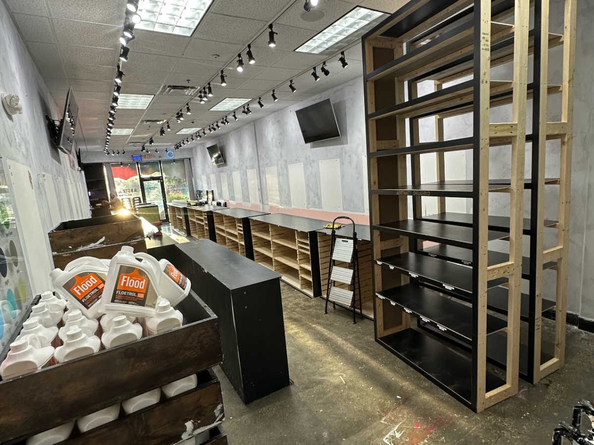 Empty store interior with shelves, counter, and overhead lights.