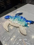 Abstract turtle art on a table with blue and white paint.